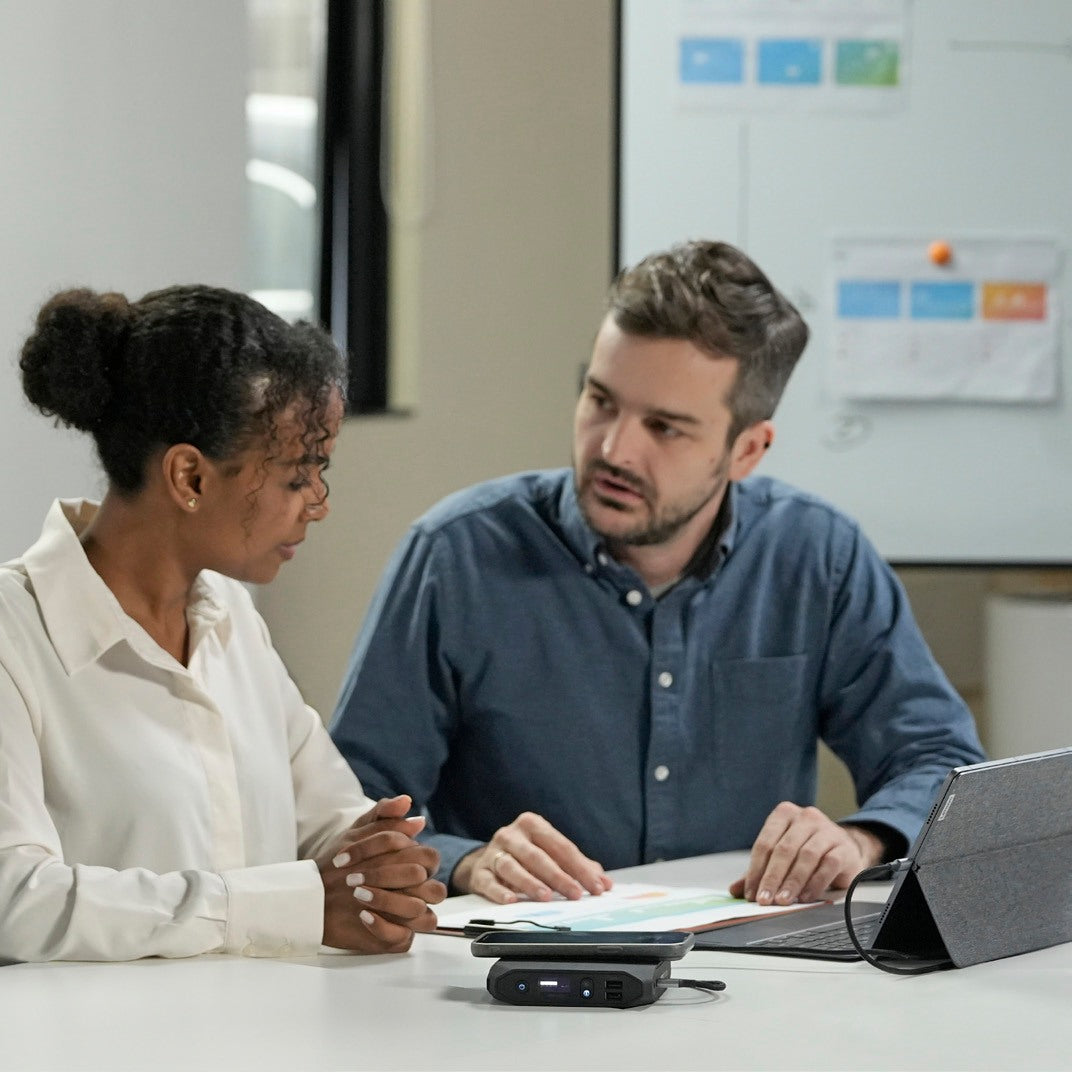 Two colleagues working at a table with an Omnicharge power bank