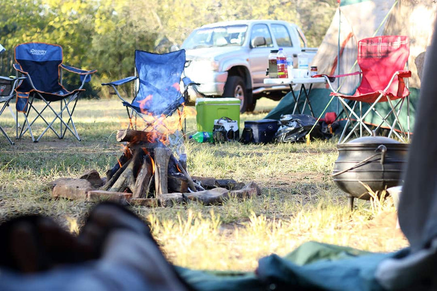 A campsite with camping chairs arranged around a campfire