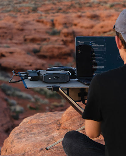 A man using a power source while camping
