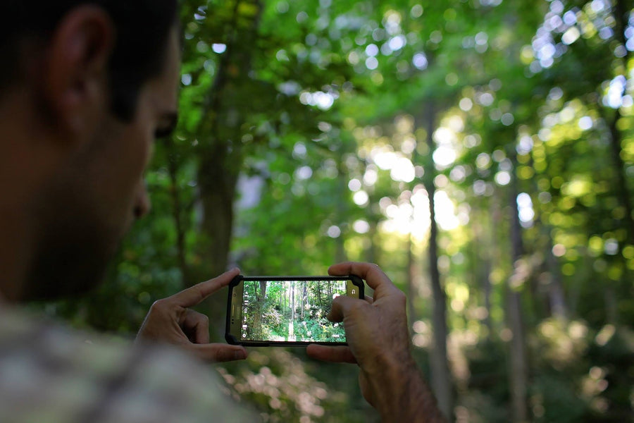 A guy with a hiking power bank take a photo while on the trail
