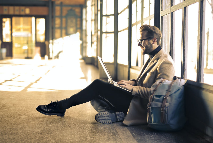 A man sitting on the floor on a laptop
