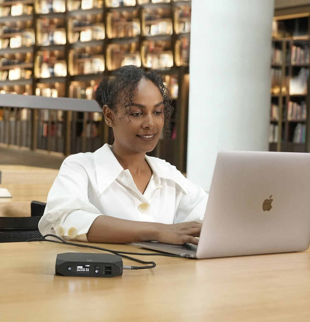 Staff member working on a laptop powered by an Omnicharge power bank