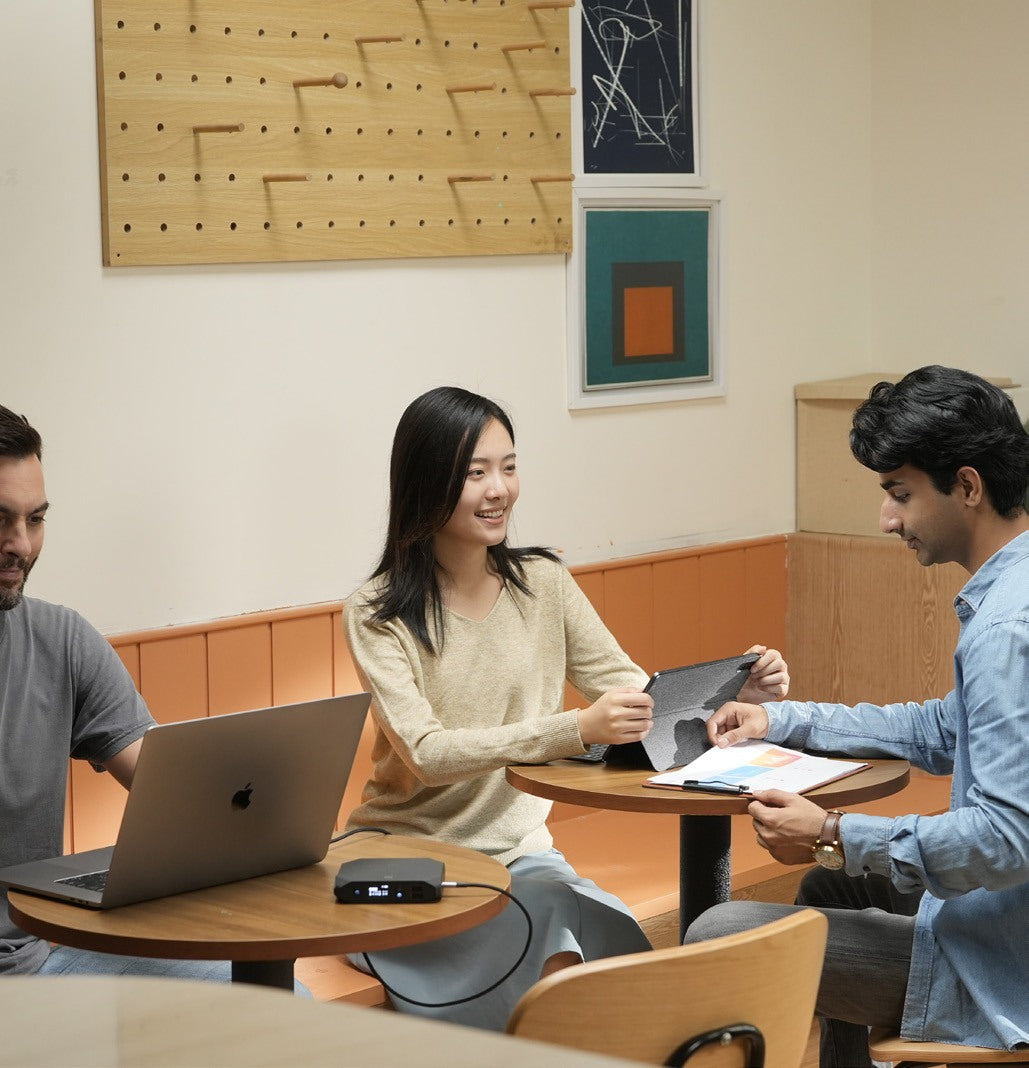Patrons sharing a table with a laptop and Omnicharge power bank
