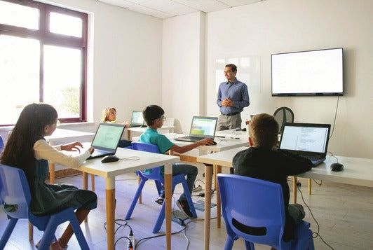 Teacher leading a class with students on laptops