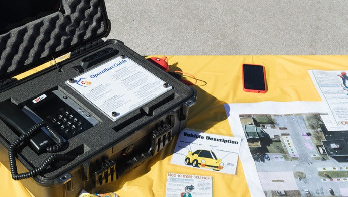 911 training unit in a hard case at an event table